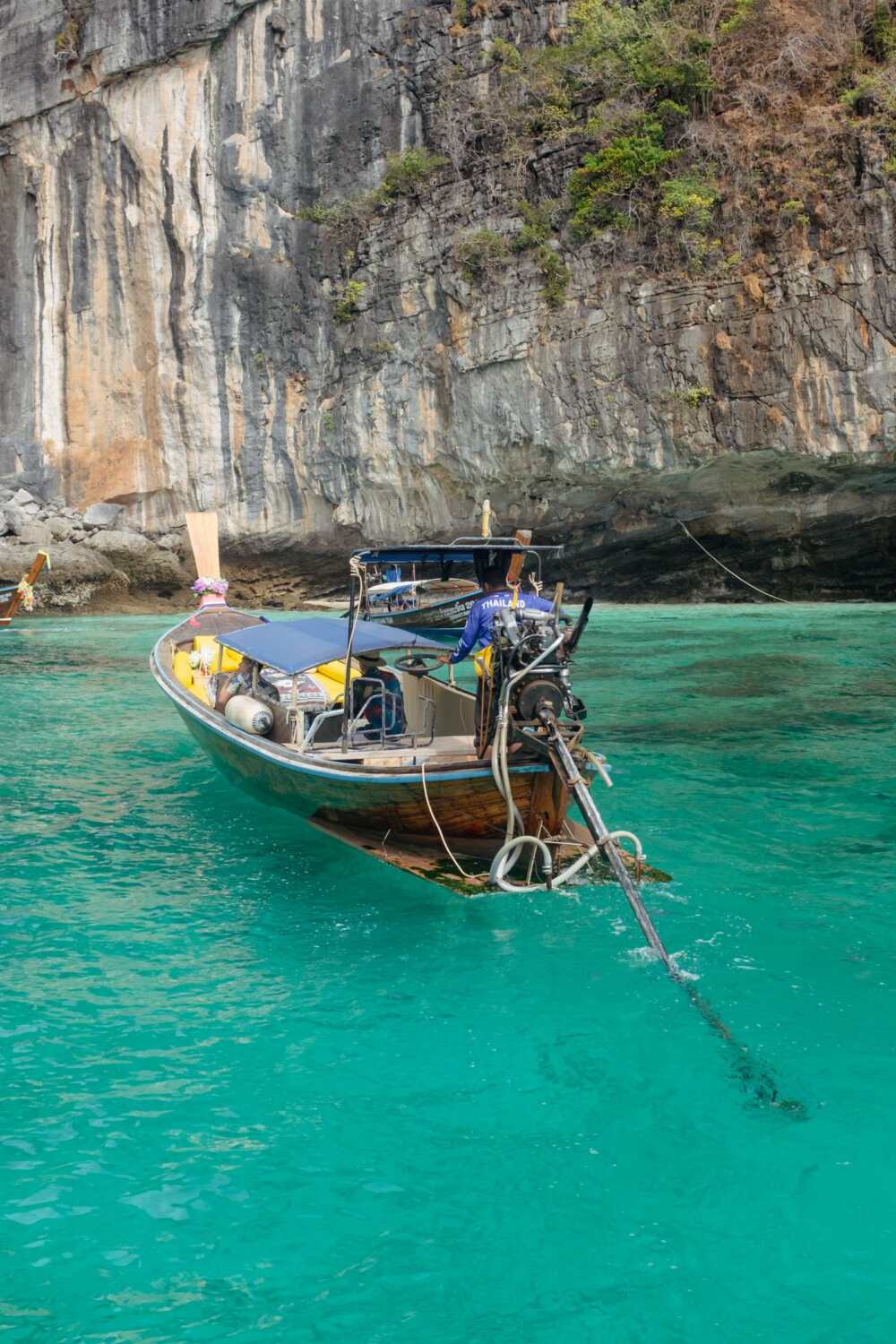 Longtail boat tradizionale su acqua turchese in Thailandia